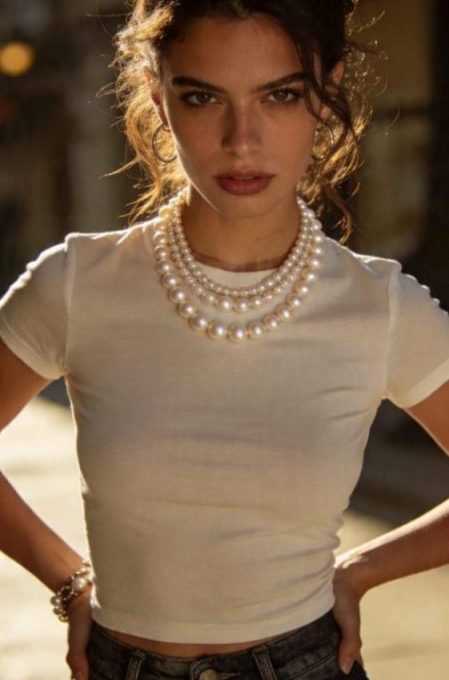Mujer joven combinando un collar de perlas modernas con ropa casual