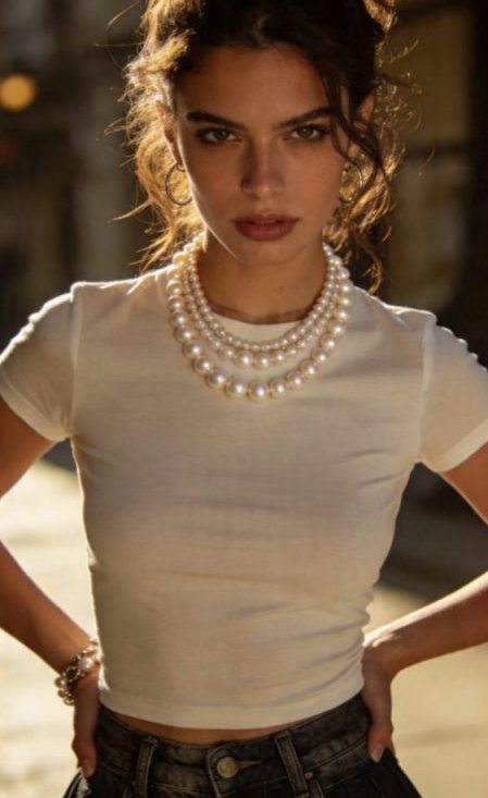 Mujer joven combinando un collar de perlas modernas con ropa casual